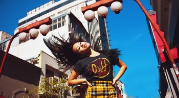 Girl in Black and Yellow Crew Neck T-shirt Standing Near Brown and White Concrete Building