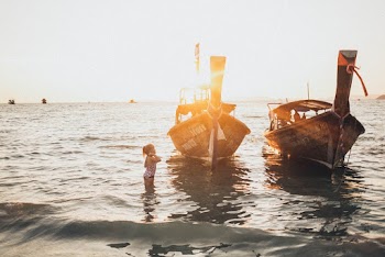Girl In Body Of Water Near Boat