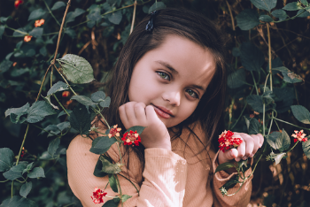 Girl in Brown Long-sleeved Top Holding Red Flowers