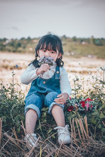 Girl in Dungaree Holding Flowers