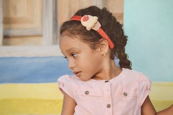 girl in pink dress and red headband