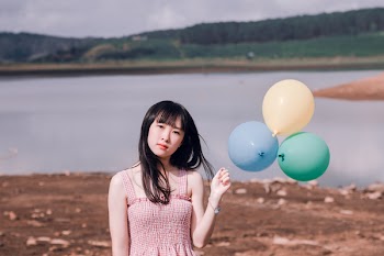 Girl in Pink Sleeveless Top Holds Three Party Balloons