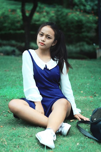 Girl in White and Blue Long-sleeved Dress Sitting on Green Grass Lawn
