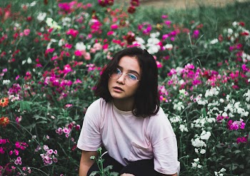 Girl in White T-shirt Surrounded by Flowers