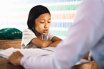 girl looking at white notebook