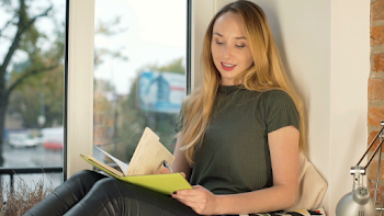 Girl looking happy while writing thoughts in her diary by the ...