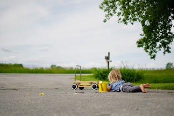 Girl Lying on Road in Front of Cart