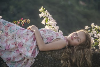 Girl Lying on Rock Beside Flowers