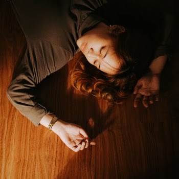 Girl Lying on the Wooden Floor Beside Source of Light · Free Stock Photo