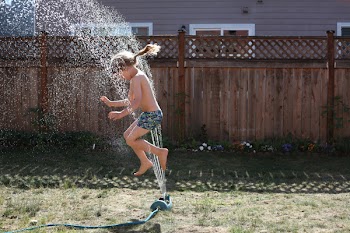Girl Playing on Field With Sprinkle of Waters