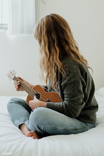 Girl playing ukulele on her bed during quarantine  | Free  photo - 2328711