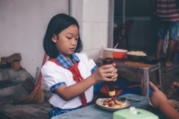 Girl Putting Ketchup on Food
