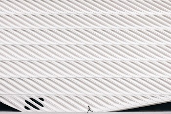 Girl Running Past Modern Architecture