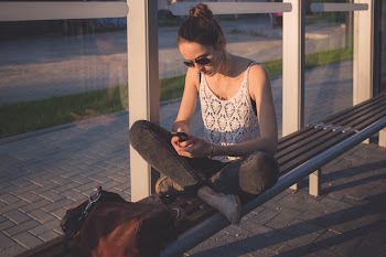 Girl sitting at tram stop