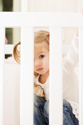 Girl Sitting in Crib