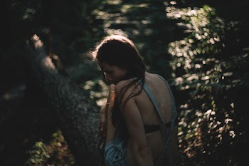Girl sitting on a tree trunk