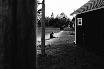 girl sitting on grass near house