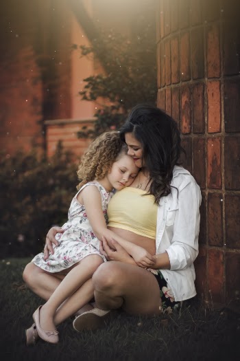 Girl Sitting On Woman's Leg 