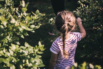 Girl Standing Between Green Plants