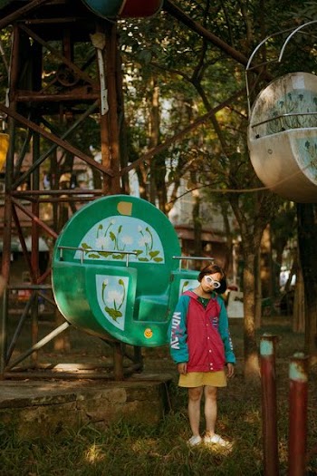 girl standing in front of green ferris wheel