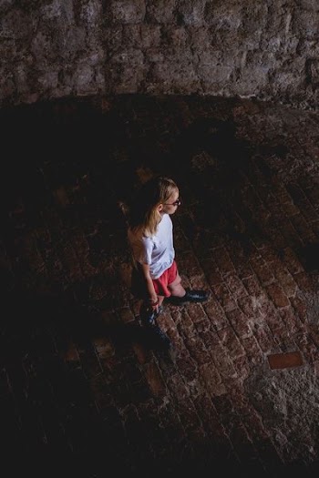 girl standing on brick floor
