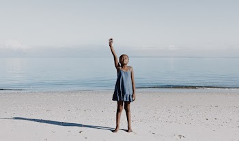 Girl Standing on White Sand