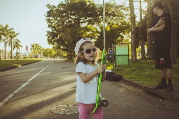 Girl Standing While Holding Green Skateboard