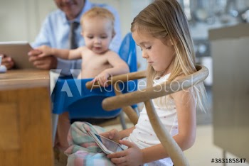 Girl using digital tablet in chair