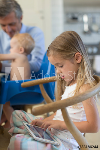 Girl using digital tablet in chair