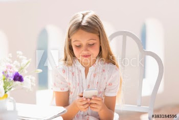 Girl using smart phone on sunny patio