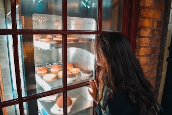 Girl Watching on Assorted Baked Pastries Beside Window Pane