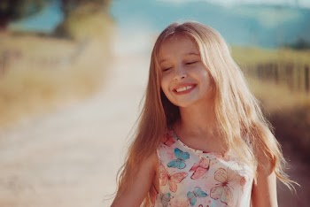 Girl Wearing Butterfly Printed Dress Smiling