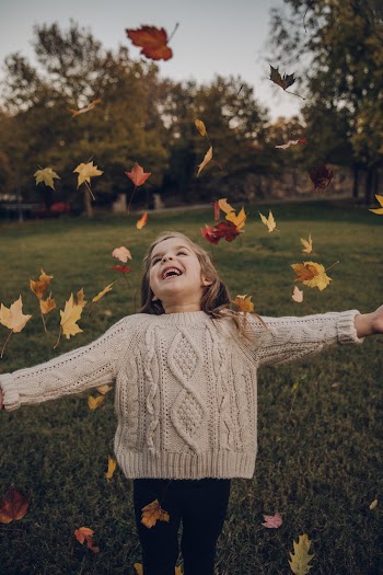 Girl Wearing Knitted Sweater Standing Outside With Leaves Falling