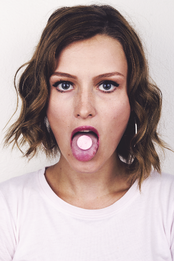 Girl Wearing White Shirt Showing Tongue With Tablet