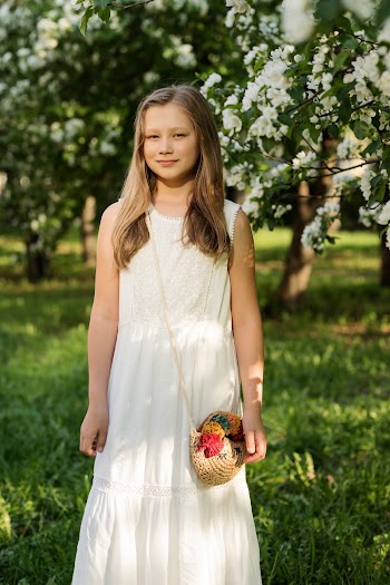 Girl Wearing White Sleeveless Dress Standing and Smiling in Green Open Field
