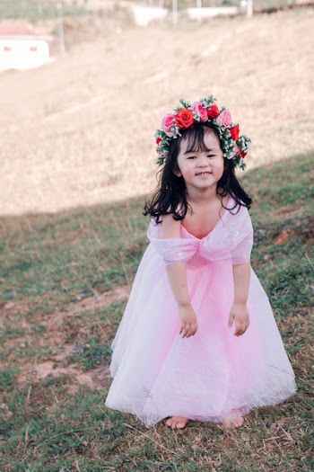 Girl With Pink Flowers Headdress Standing on Grass Field