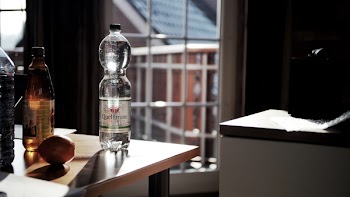 Glass Bottle on Brown Wooden Table