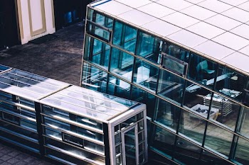glass building beside glass train