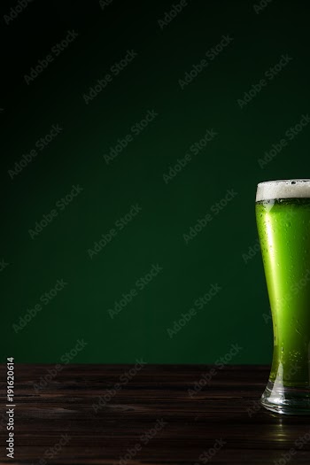glass of green beer on wooden table, st patricks day concept