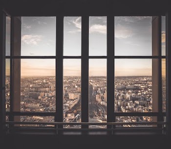 glass panel window showing city buildings under blue sky