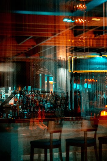 Glass Wall Along The Bar Of A Business Establishment Reflecting People Walking From The Street  Outside