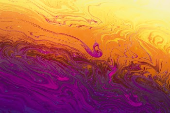 Gleaming wavy purple orange and yellow abstract background Free Photo