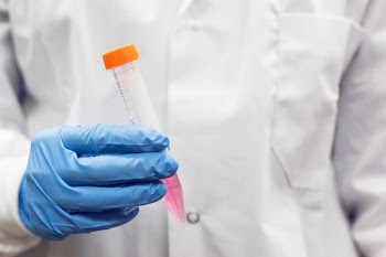 Gloved Hand And Test Tube