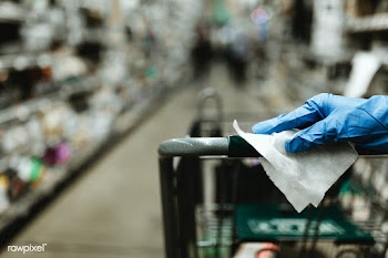 Gloved hand with a tissue paper on a shopping cart in a supermarket du.. | Free  photo - 2310146