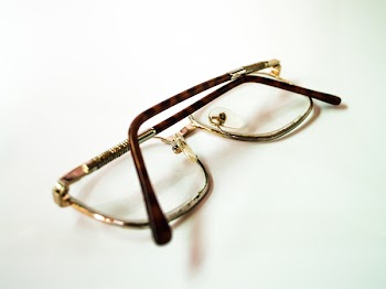 Gold Framed Eyeglasses on White Surface
