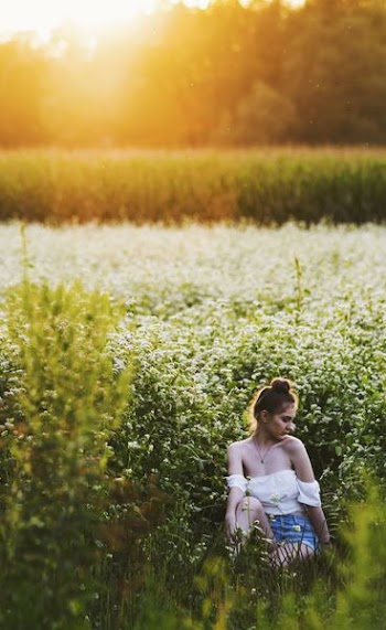 golden hour photography of woman in white top and blue denim shorts
