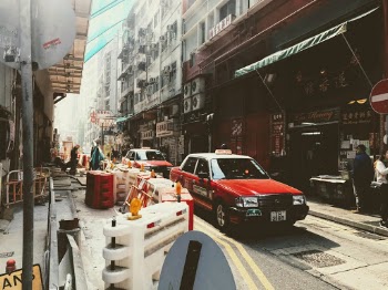 Got this photo walking down through Hong Kong Central area. Just right before noon when sun shined over the entire street and got a moment where traditional taxis were passing by. Creating this memorable moment from my trip.