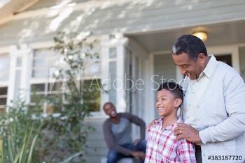 Grandfather and grandson talking in front yard