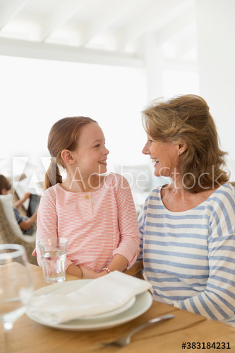 Grandmother and granddaughter talking at able