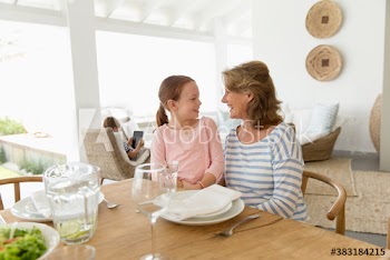 Grandmother and granddaughter talking at lunch table